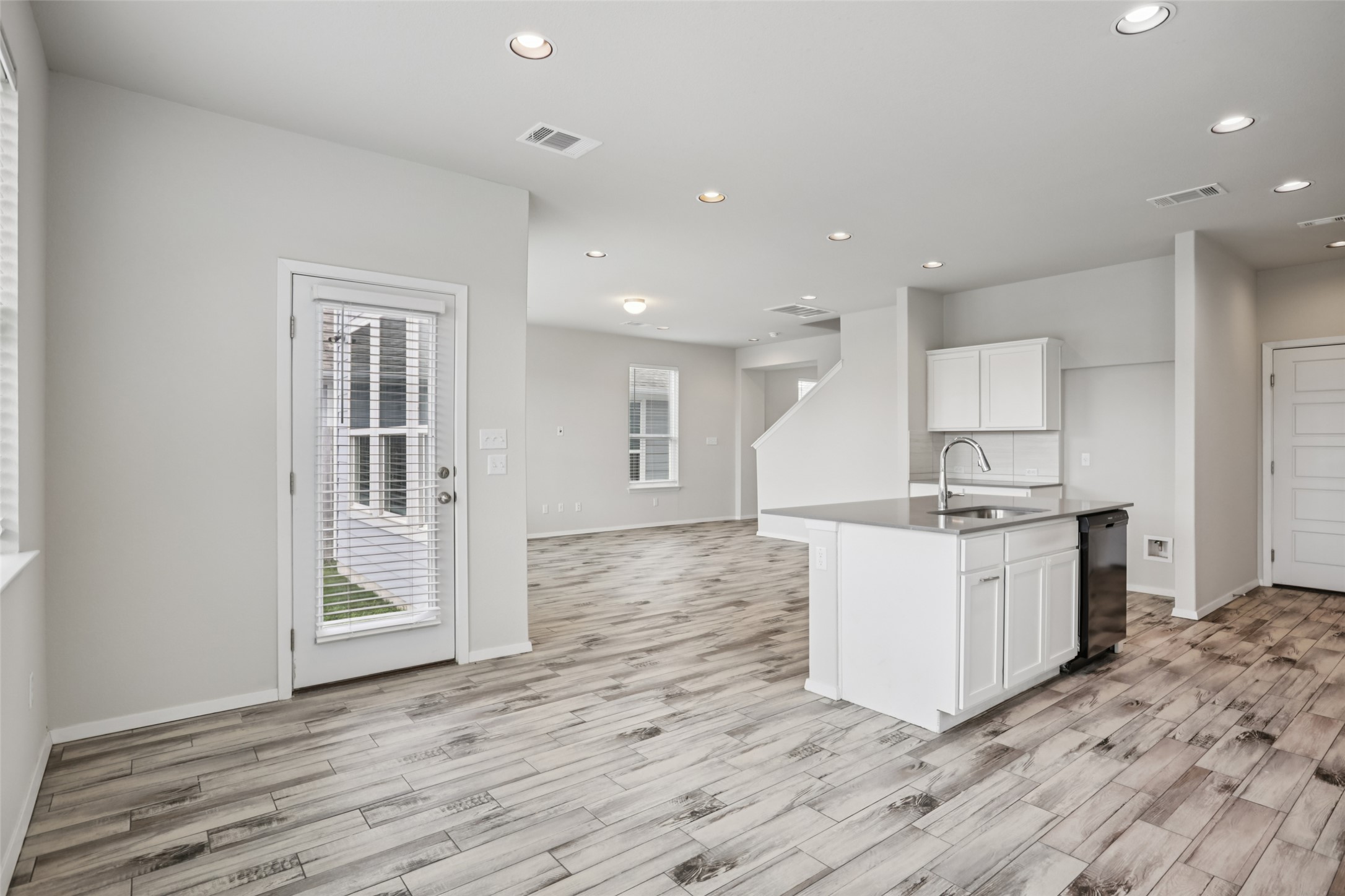 293 Gaida Loop Georgetown, TX 78628 - Photo 7 of 39 a kitchen with a sink a stove cabinets and wooden floor