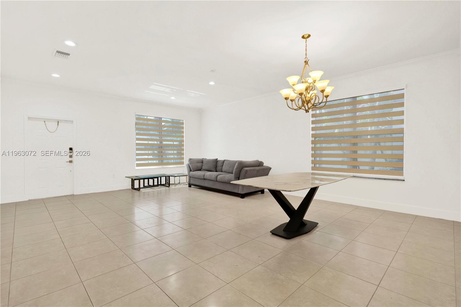 23824 Southwest 107th Place Homestead, FL 33032 - Photo 18 of 33 a living room with furniture and a chandelier