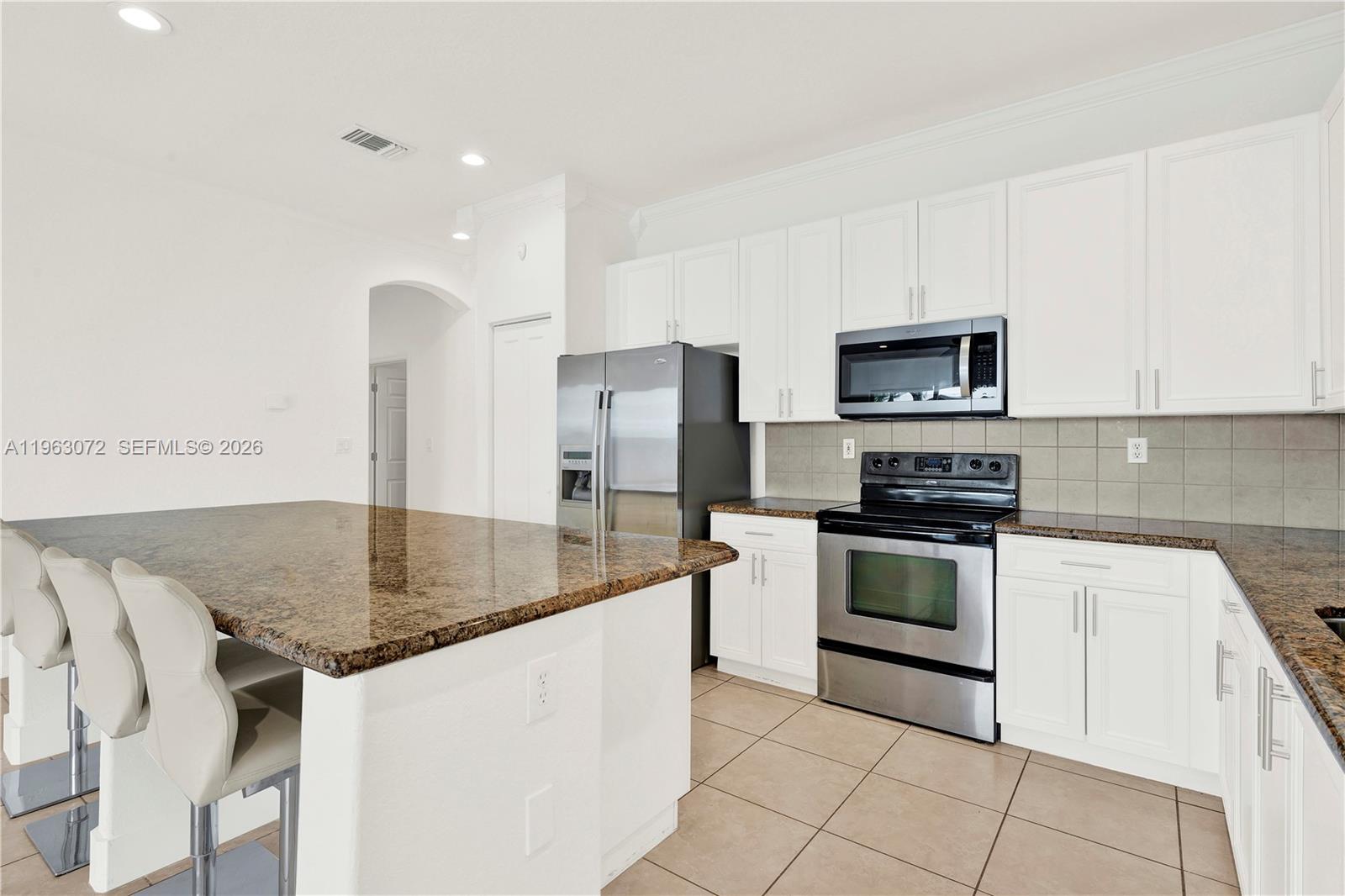 23824 Southwest 107th Place Homestead, FL 33032 - Photo 10 of 33 a kitchen with stainless steel appliances granite countertop a sink and a stove