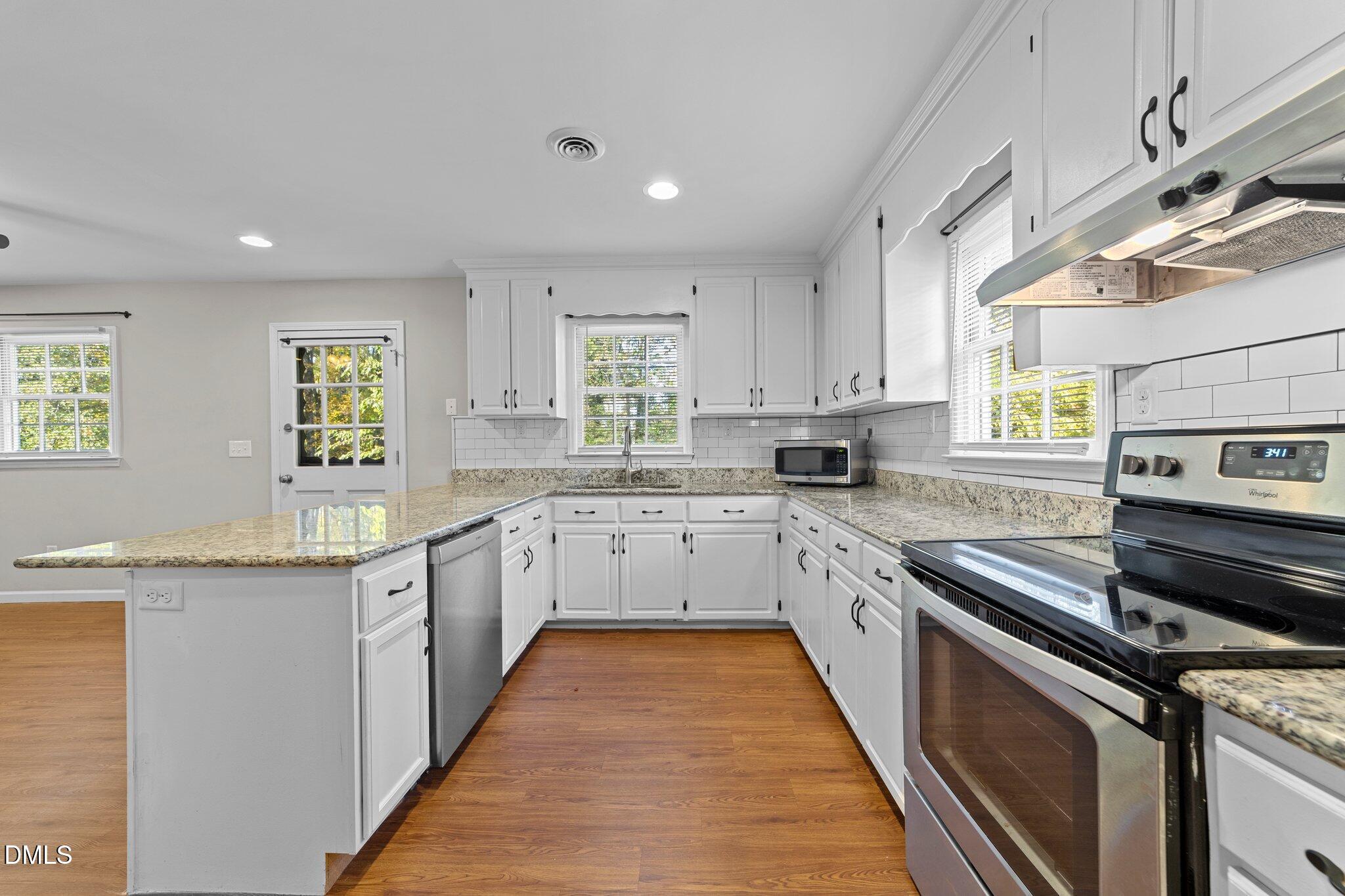412 2nd Street Apex, NC 27502 - Photo 12 of 39 a large kitchen with stainless steel appliances granite countertop a stove a sink and a microwave