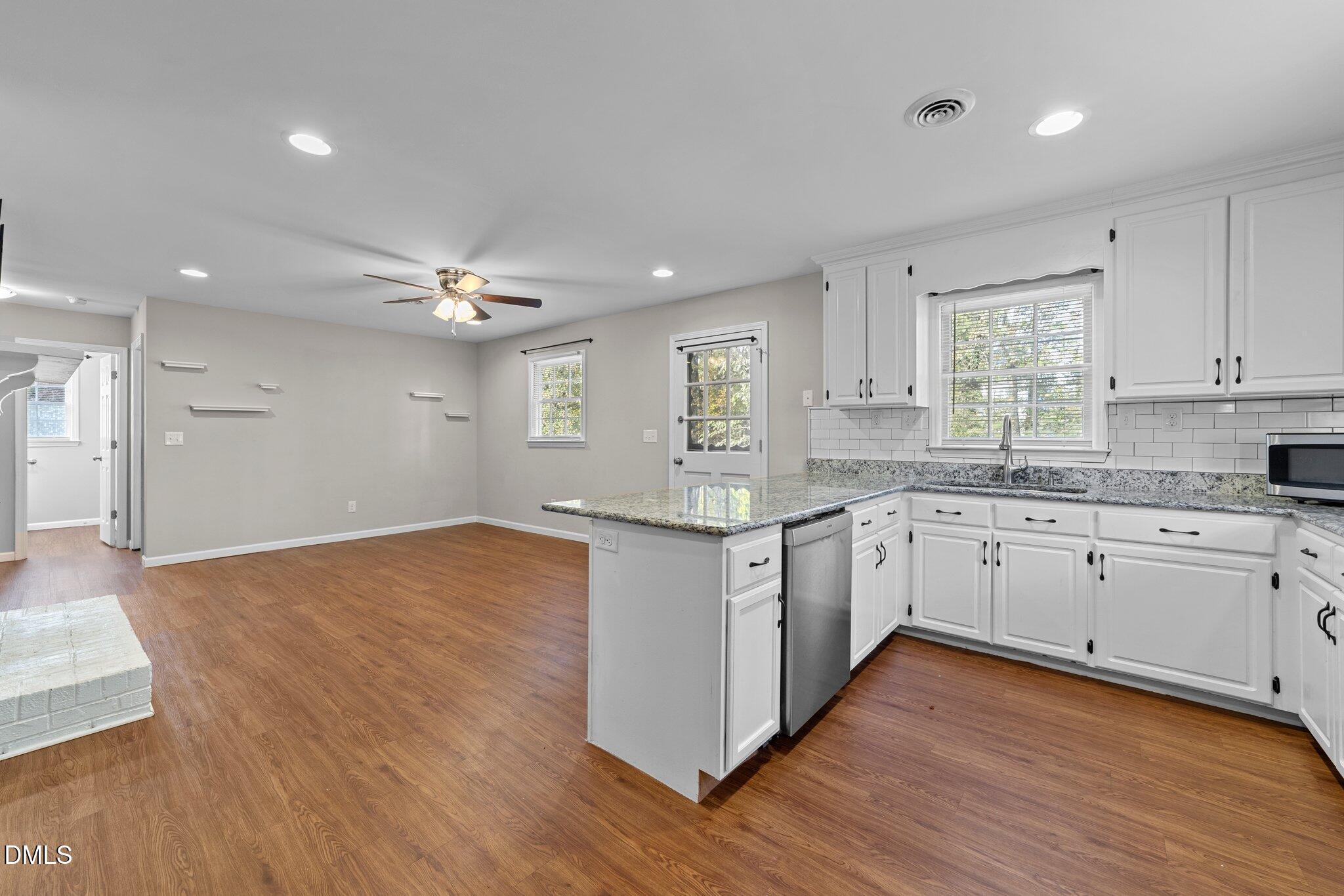 412 2nd Street Apex, NC 27502 - Photo 13 of 39 a kitchen with wooden floors and white cabinets