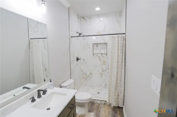 a bathroom with a sink toilet and shower