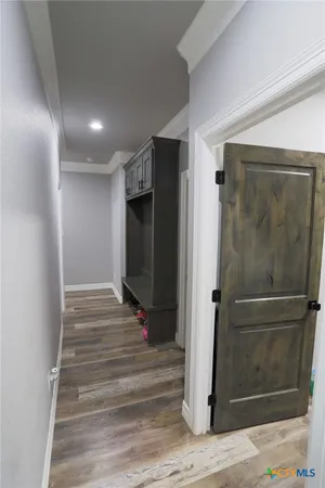 a view of a hallway with wooden floor and staircase