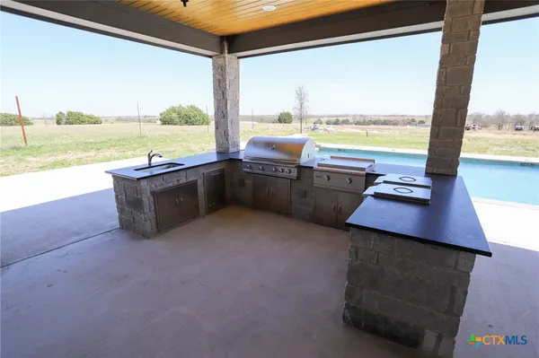 a kitchen with stainless steel appliances wooden floor and a large window