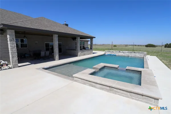 a view of a house with pool and outdoor seating