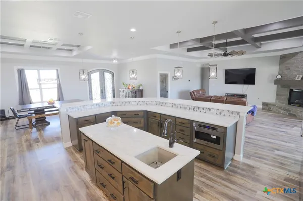 a large kitchen with a table chairs and a wooden floor