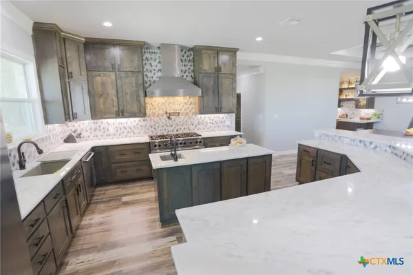 a kitchen with stainless steel appliances granite countertop a sink stove and refrigerator