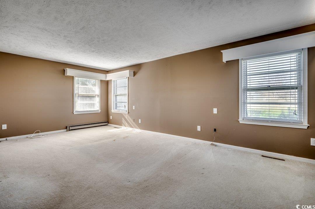 3701 South Green Sea Road Loris, SC 29569 - Photo 23 of 31 Carpeted spare room with a baseboard heating unit and a textured ceiling