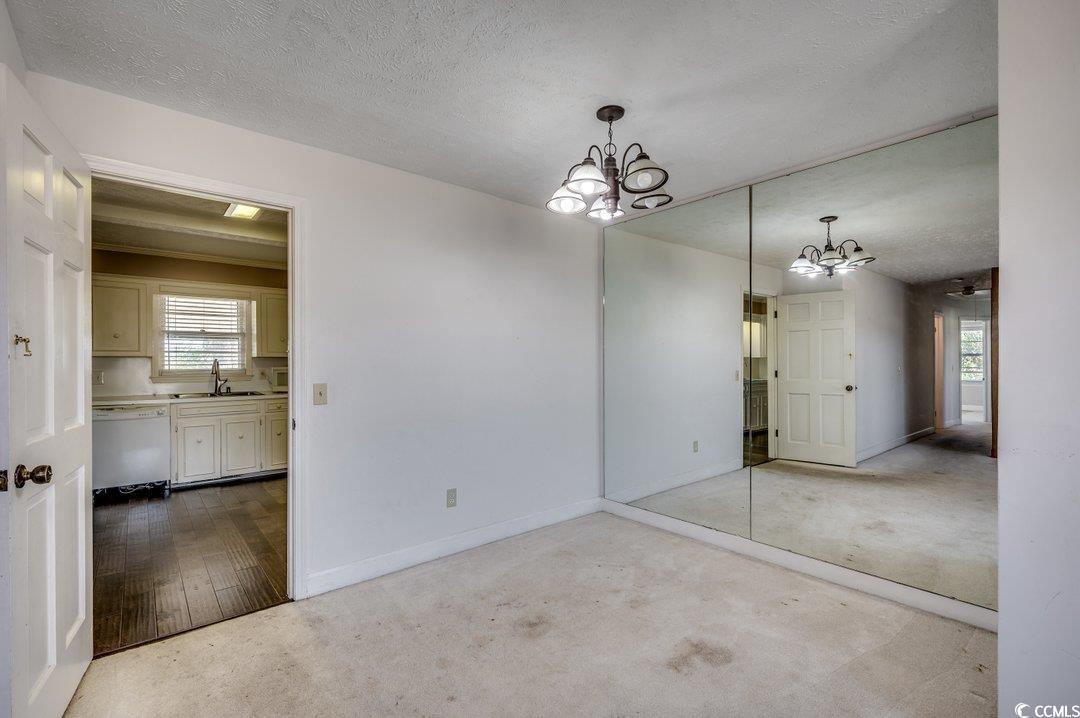 3701 South Green Sea Road Loris, SC 29569 - Photo 5 of 31 Unfurnished room with a chandelier, a textured ceiling, light hardwood / wood-style flooring, and sink