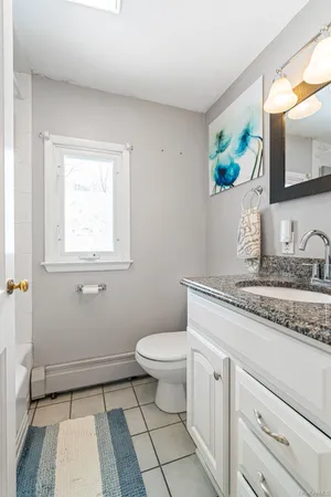 a bathroom with a granite countertop toilet sink and mirror