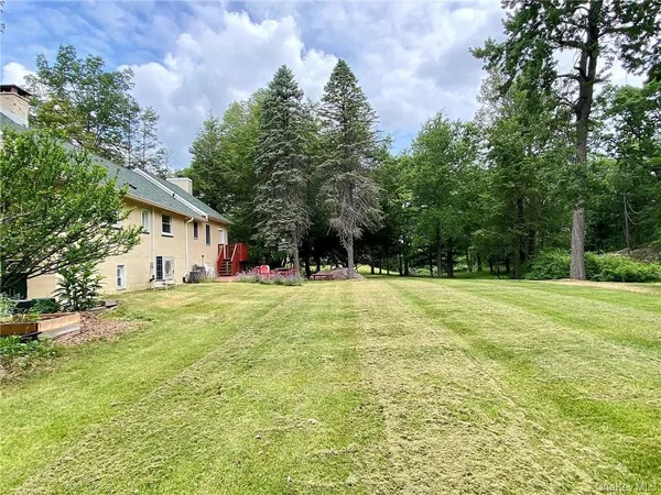 a view of a house with a backyard and a tree