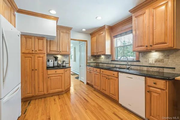 a kitchen with stainless steel appliances granite countertop a stove a sink dishwasher a refrigerator and cabinets with wooden floor
