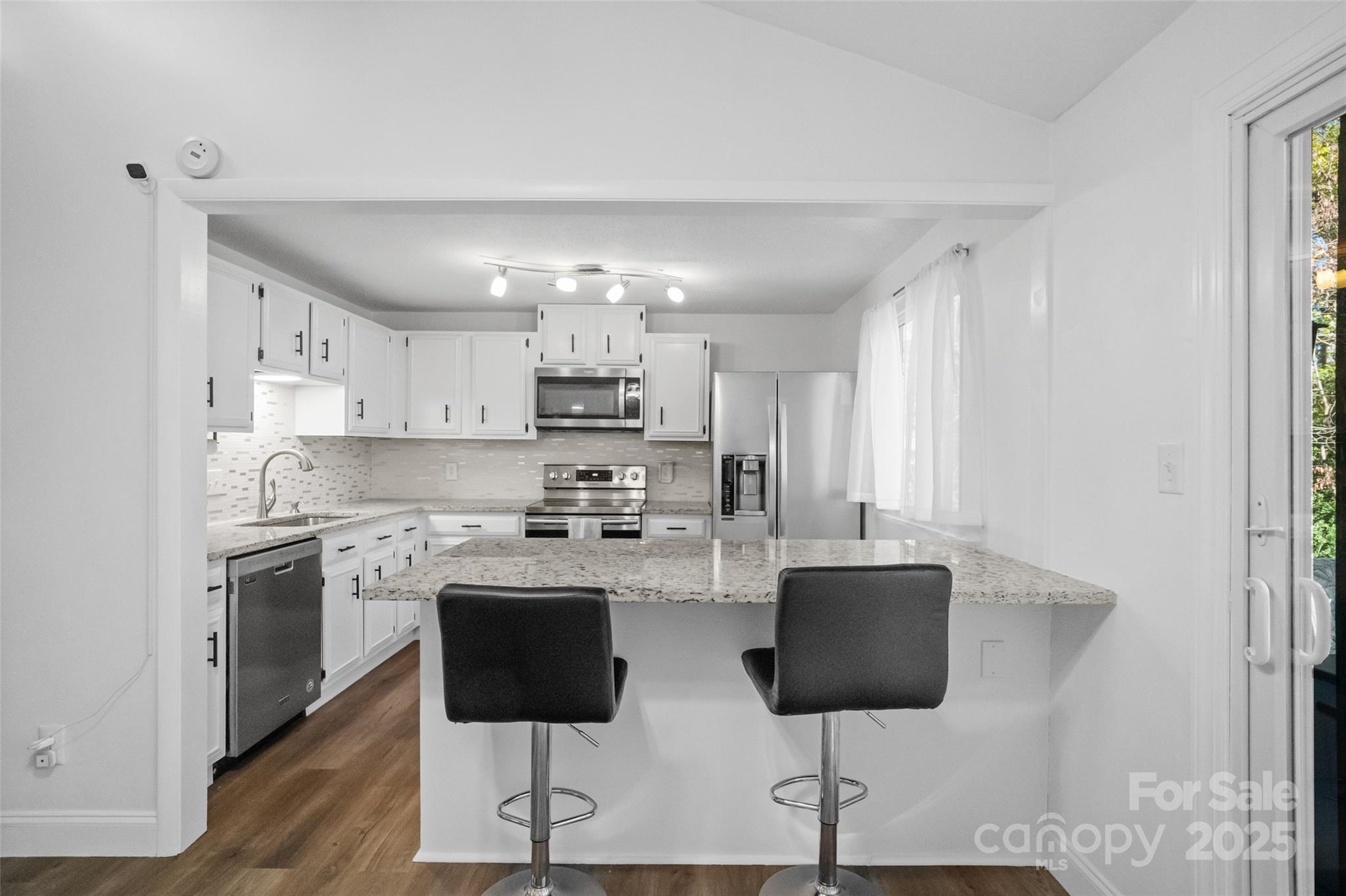 5709 Shadow Creek Road Charlotte, NC 28226 - Photo 10 of 39 a kitchen with stainless steel appliances granite countertop a stove top oven a sink dishwasher and a refrigerator with wooden floor