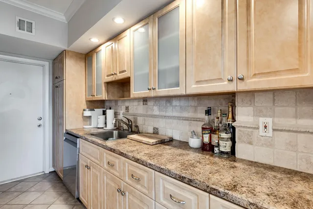 a kitchen with granite countertop a sink a stove and cabinets