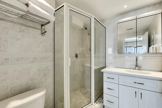 a bathroom with a shower sink vanity and mirror