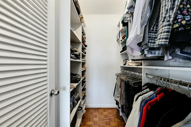 a view of walk in closet with clothes and shoes