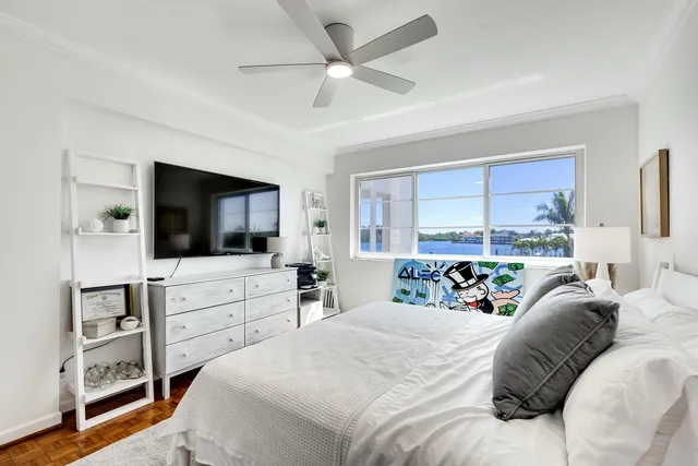 a bed room with a bed a television and a large window