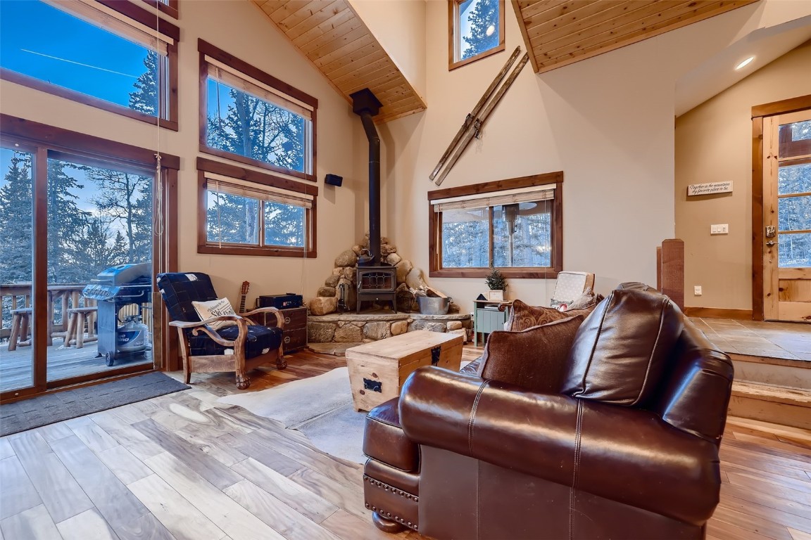 490 Adventure Road Alma, CO 80420 - Photo 5 of 28 Living room with light hardwood / wood-style flooring, a wood stove, high vaulted ceiling, and wood ceiling
