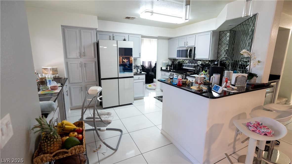 6429 Winding Ridge Las Vegas, NV 89156 - Photo 12 of 16 A well-lit culinary space showcases white cabinetry and sleek black countertops.