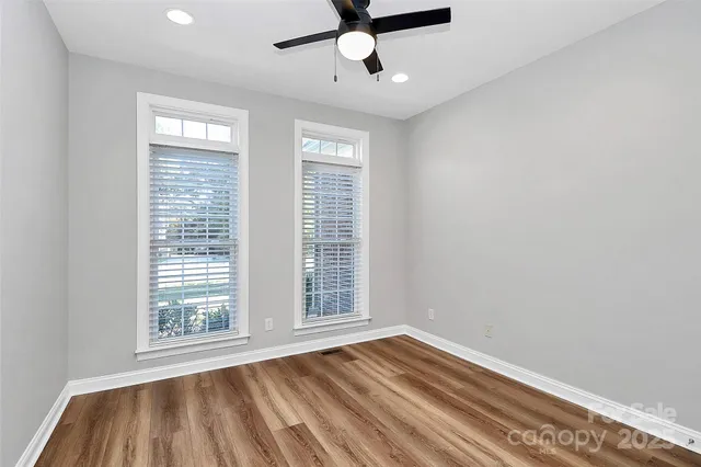 a view of an empty room with a window and cabinet