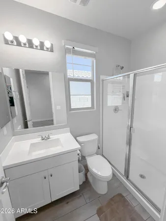 a spacious bathroom with a toilet a sink and a mirror