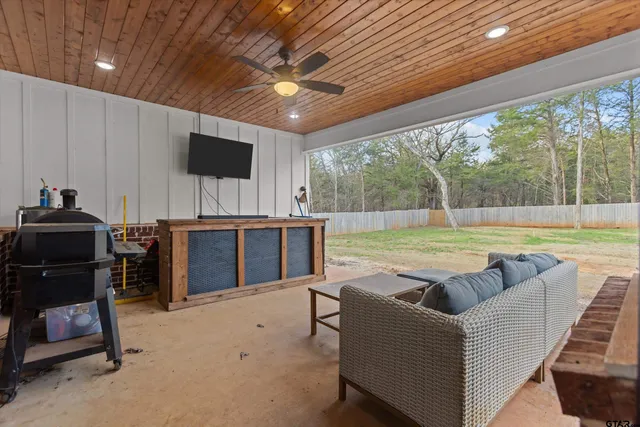 a living room with furniture a flat screen tv and a large window