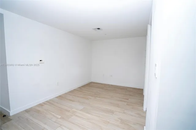 a kitchen with a wooden floor and white cabinets