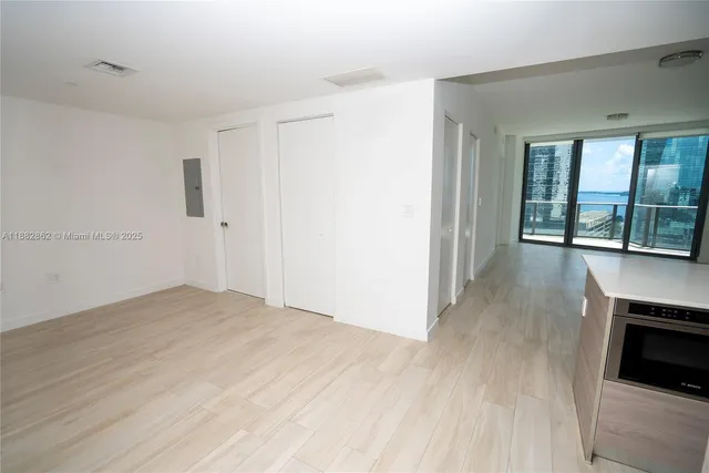 a living room with stainless steel appliances kitchen island hardwood floor and sink