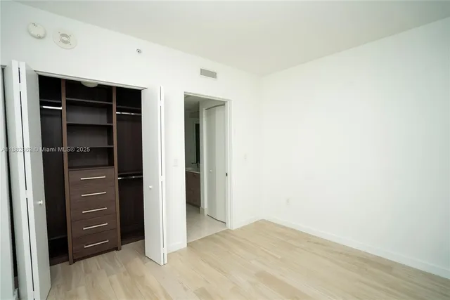 an empty room with sliding door and wooden floor