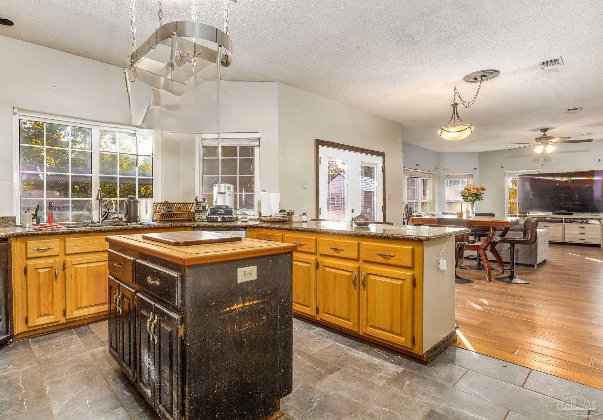 4616 B B Lowery Road Milton, FL 32583 - Photo 18 of 35 a kitchen with kitchen island granite countertop a stove a sink a dining table and chairs