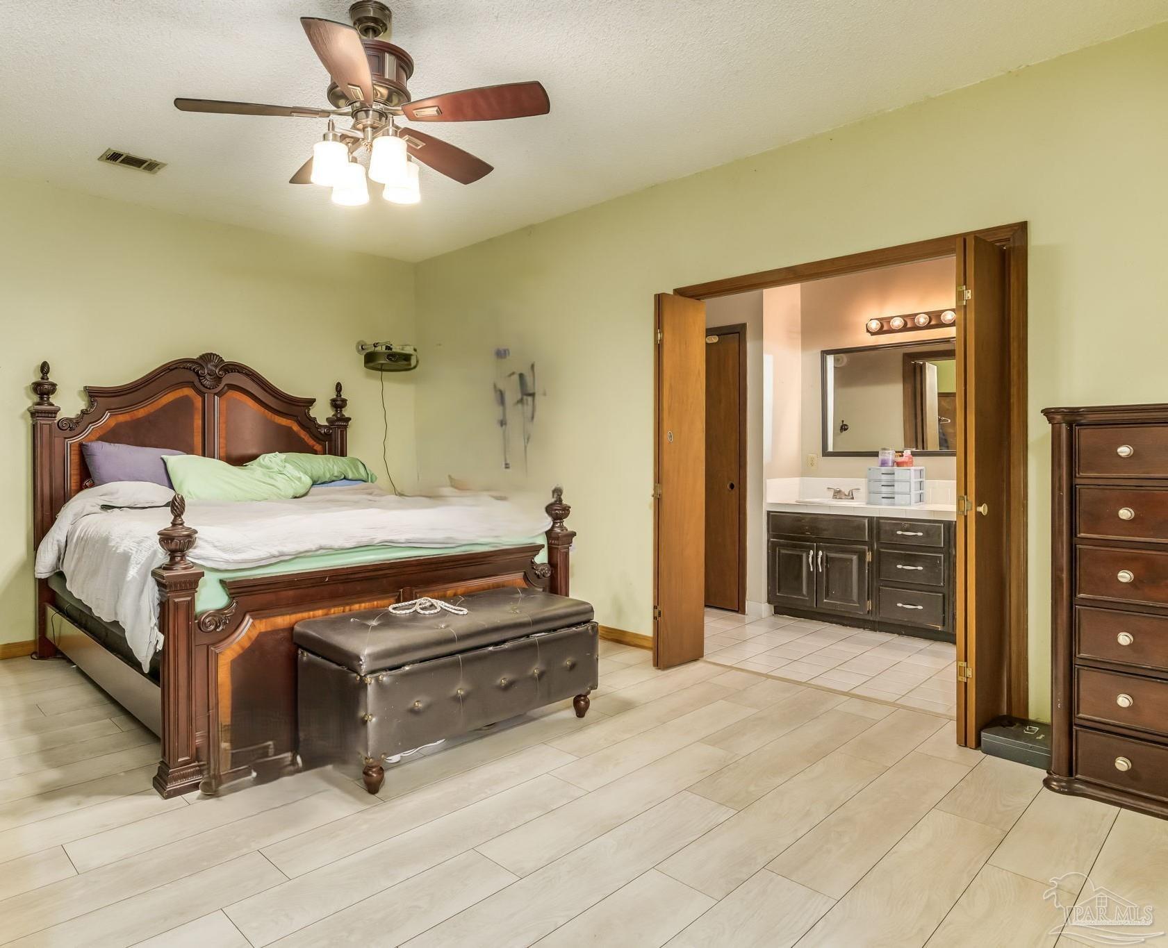 4616 B B Lowery Road Milton, FL 32583 - Photo 22 of 35 a bedroom with a bed and a chandelier