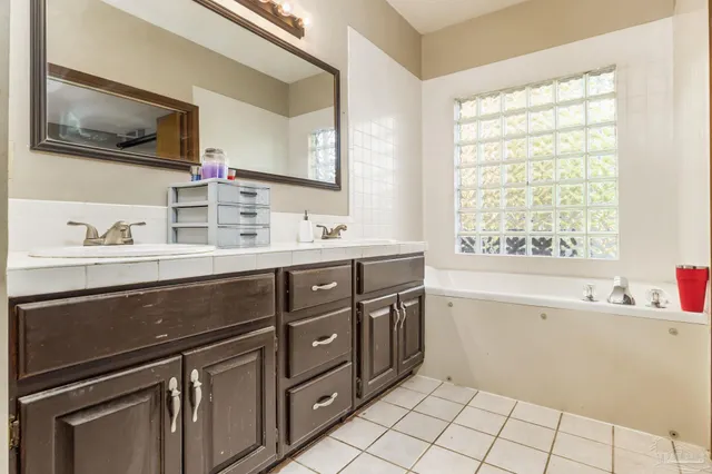 a spacious bathroom with a double vanity sink mirror and bathtub