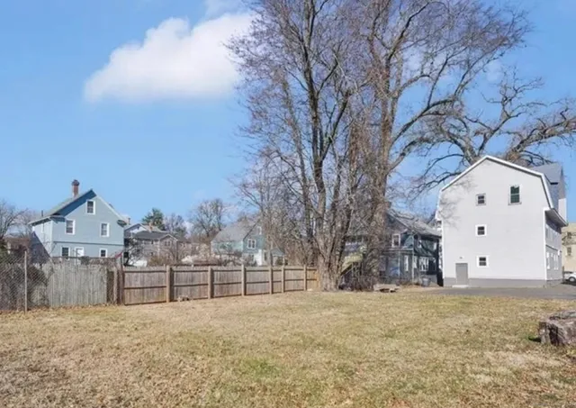 a view of white house with a yard covered in snow