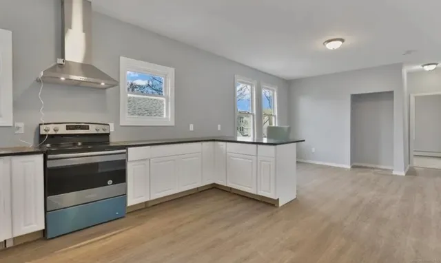 a kitchen with granite countertop white cabinets and white appliances