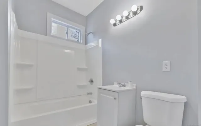 a bathroom with a bathtub a sink a toilet and a mirror