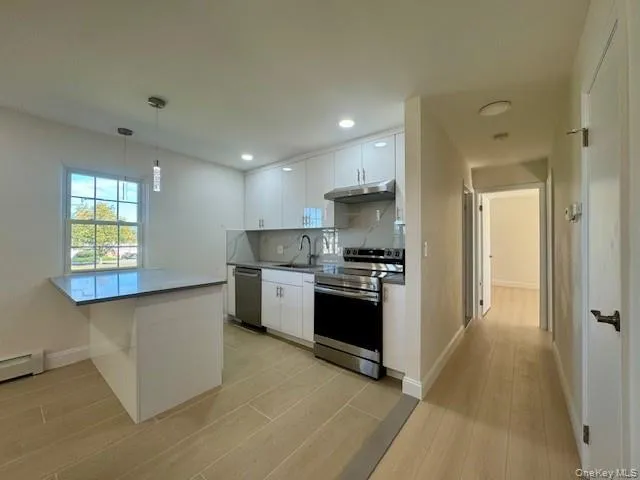 a kitchen with stainless steel appliances granite countertop a stove a sink and a refrigerator