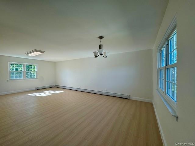 648 Old Country Road, Unit 2 Plainview, NY 11803 - Photo 8 of 13 an empty room with wooden floor cabinet and windows