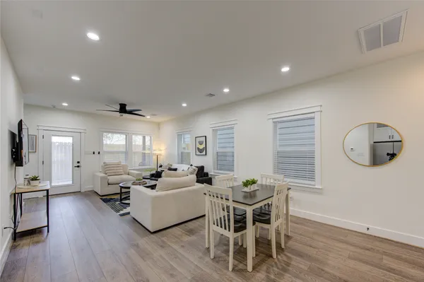 a living room with furniture a wooden floor and a large window
