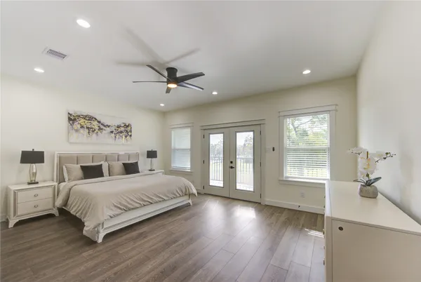 a bedroom with a large bed chandelier and a window