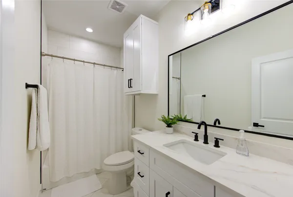 a bathroom with a double vanity sink toilet and shower