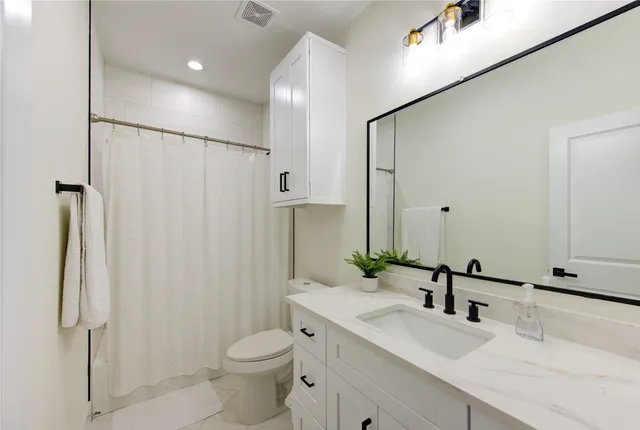 a bathroom with a double vanity sink toilet and shower