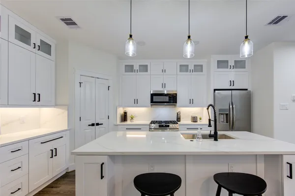 a kitchen with kitchen island a sink stove and refrigerator