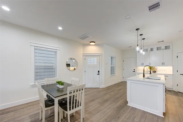 a kitchen with granite countertop a sink cabinets and wooden floor