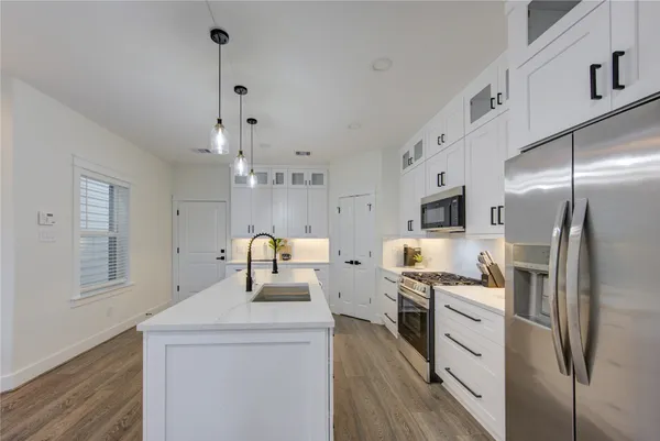 a kitchen with stainless steel appliances a refrigerator sink and microwave