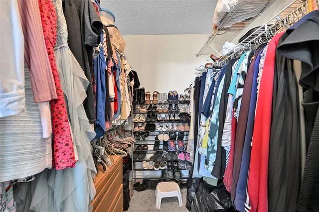 a view of walk in closet with clothes
