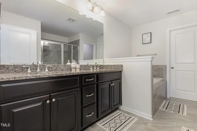 a bathroom with a granite countertop sink a mirror and a shower