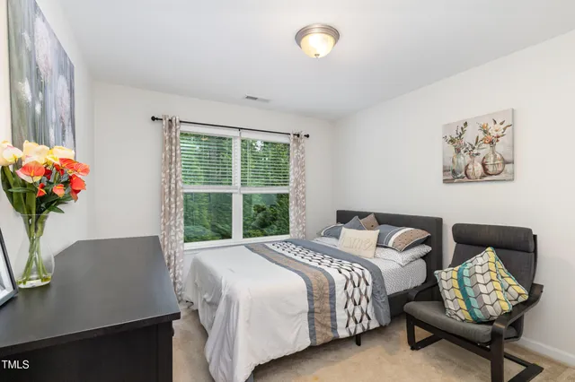 a bedroom with a bed potted plant and a window