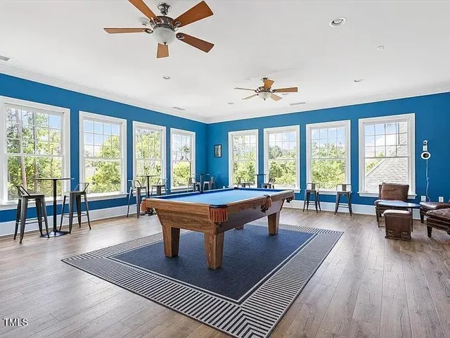 a living room with furniture a large window with wooden floor and furniture