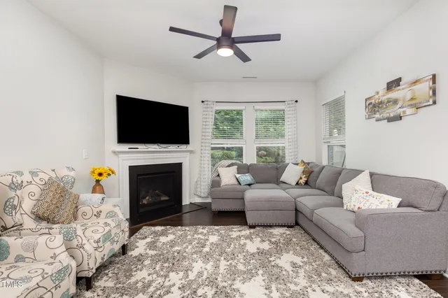 a living room with furniture a fireplace and a flat screen tv