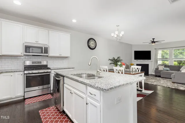 a kitchen with stainless steel appliances granite countertop a sink stove oven and microwave